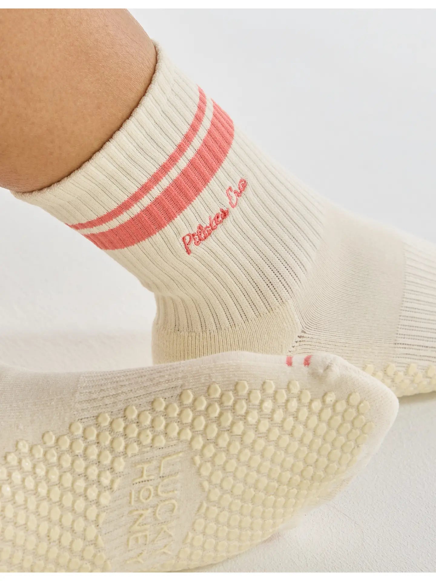 Sohlenansicht mit Grip-Design auf rosa Hintergrund