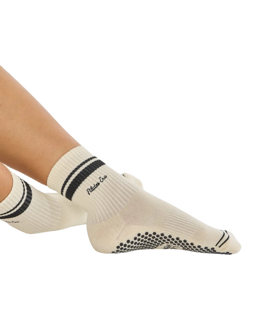 Schwarze Pilates-Grip-Socken mit weißen Streifen im Retro-Design, frontal getragen
